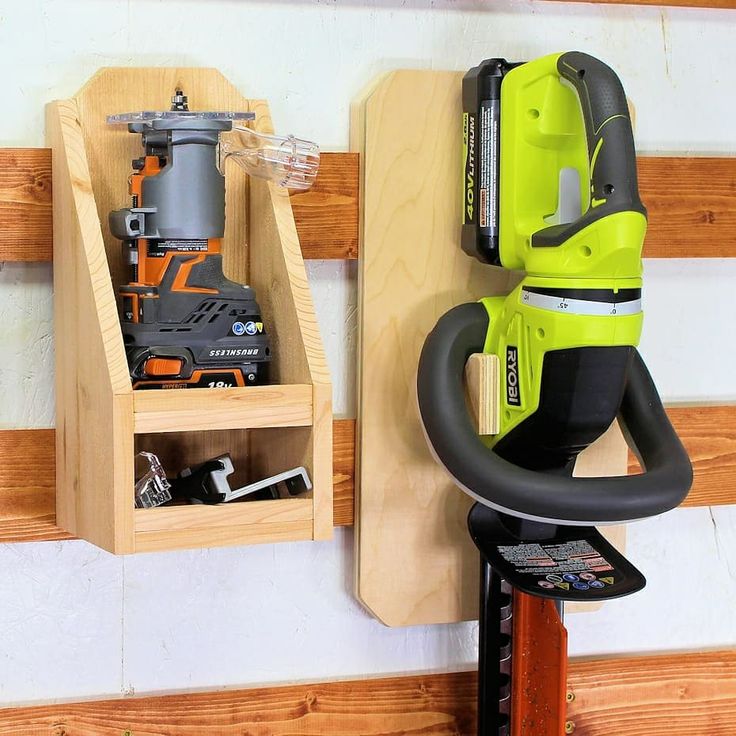 a cordless driller is mounted on the wall next to a tool holder with tools in it