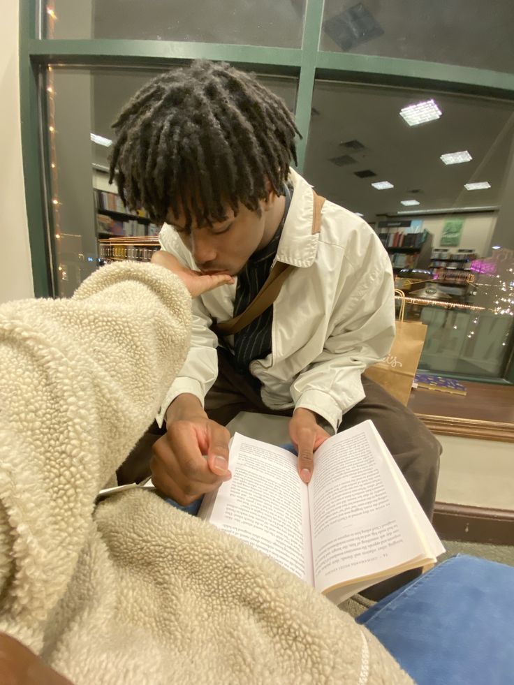 a man reading a book while sitting down