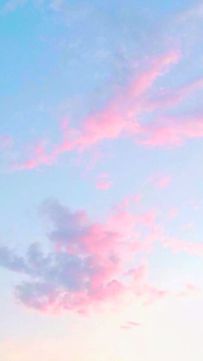 the airplane is flying high in the sky with pink and blue clouds above it at sunset