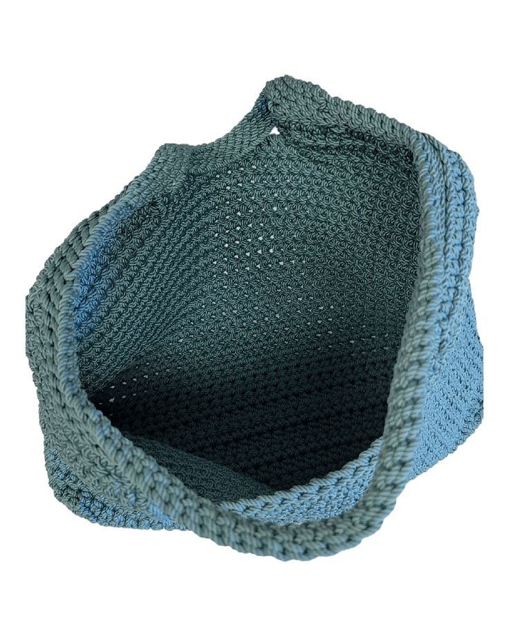 a blue and gray knitted bag sitting on top of a white surface