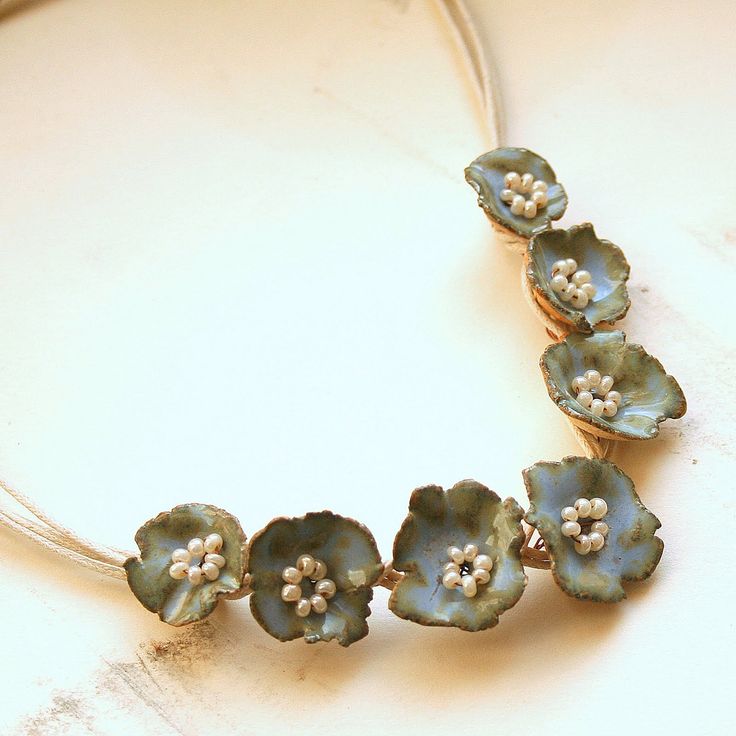 a necklace with blue flowers and white beads