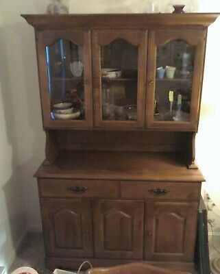 an old wooden china cabinet with glass doors