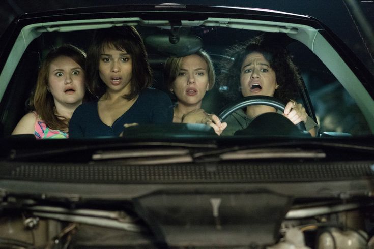 four women are sitting in the passenger seat of a car and one woman is surprised