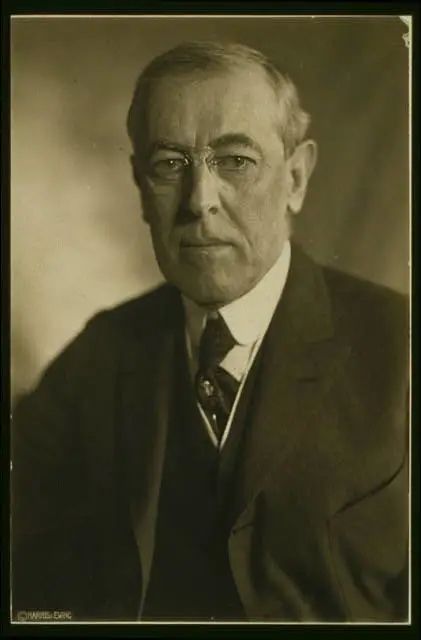 an old black and white photo of a man in a suit, tie and glasses