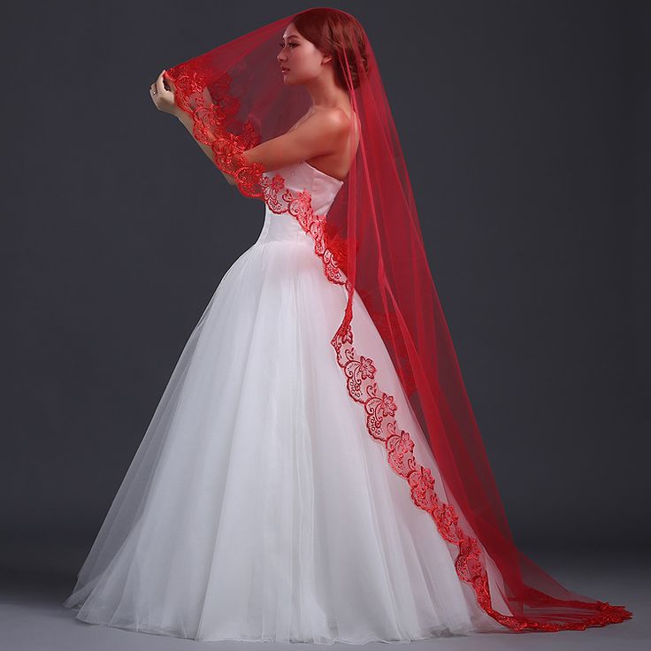 a woman in a wedding dress with a red veil