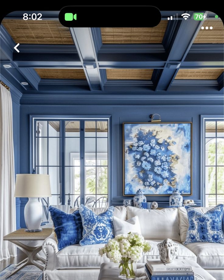 a living room with blue walls and white furniture