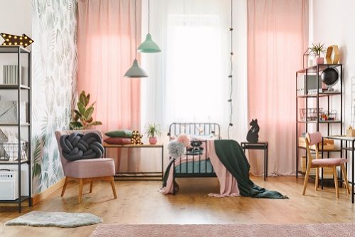 a living room filled with furniture and pink curtains