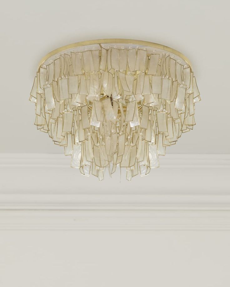 a chandelier hanging from the ceiling in a room with white walls and trimmings