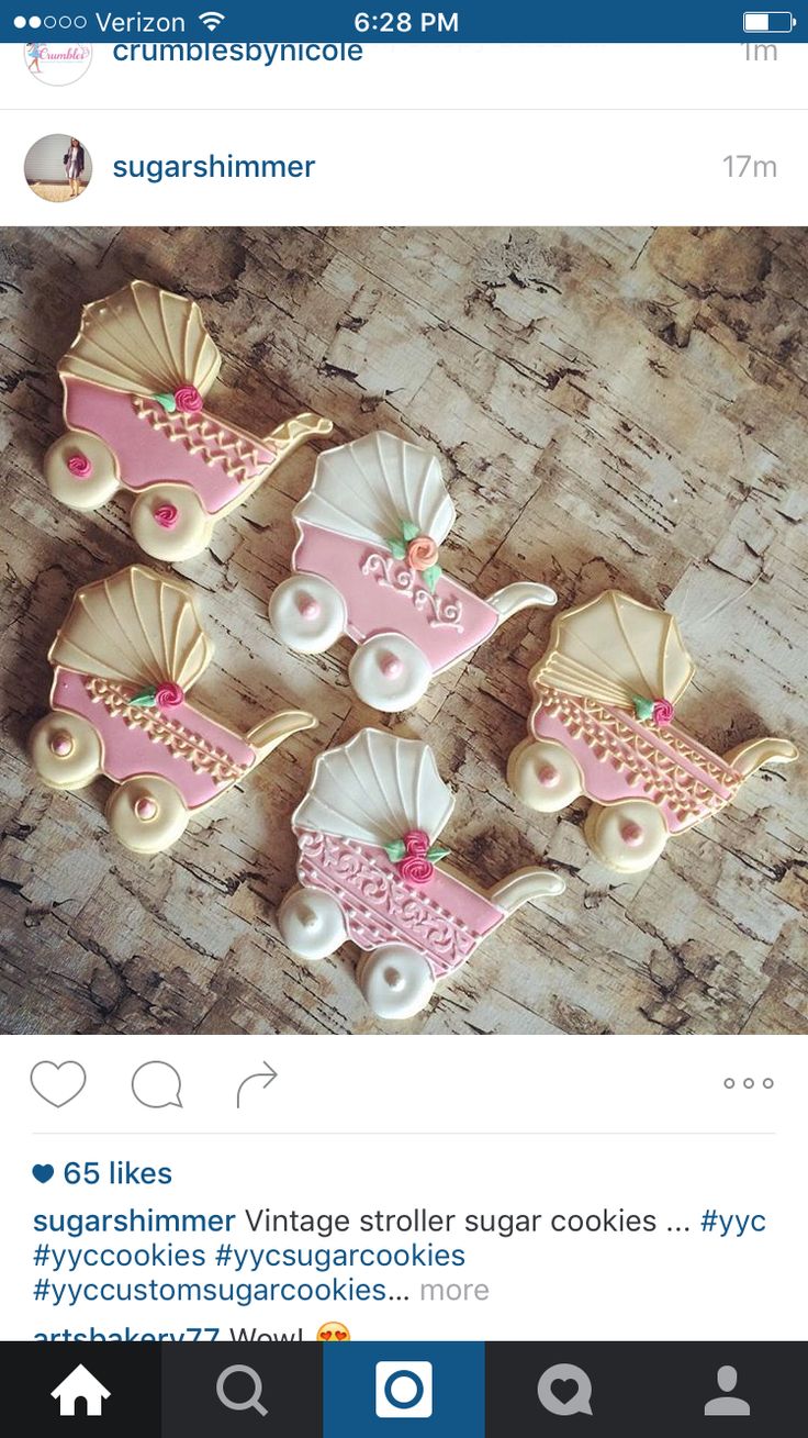 cookies decorated with pink and white icing on top of a wooden table next to an instagram post