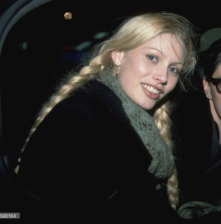 a man and woman sitting next to each other in front of a car at night