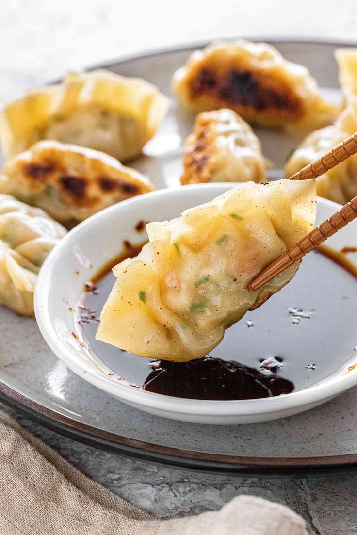 dumplings with sauce and chopsticks on a plate