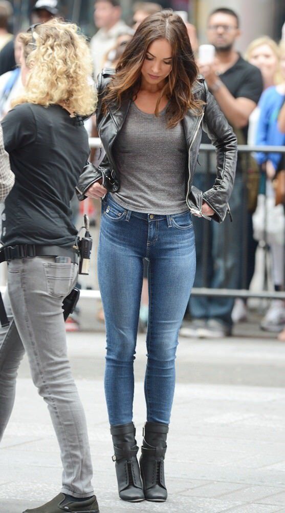 two women standing on the street talking to each other