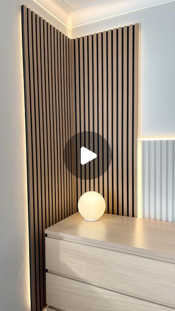 a white lamp sitting on top of a dresser next to a wooden paneled wall