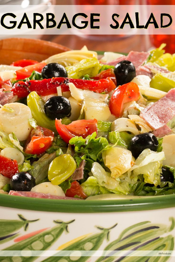 a salad with olives, lettuce, tomatoes and other vegetables in it