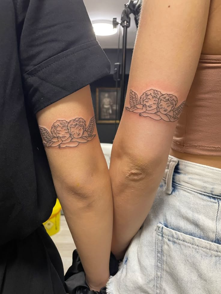 two people with matching tattoos on their arms