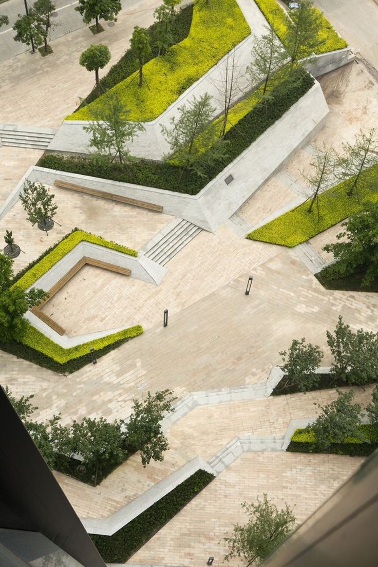 an aerial view of a skateboard park with ramps and trees in the center, surrounded by greenery