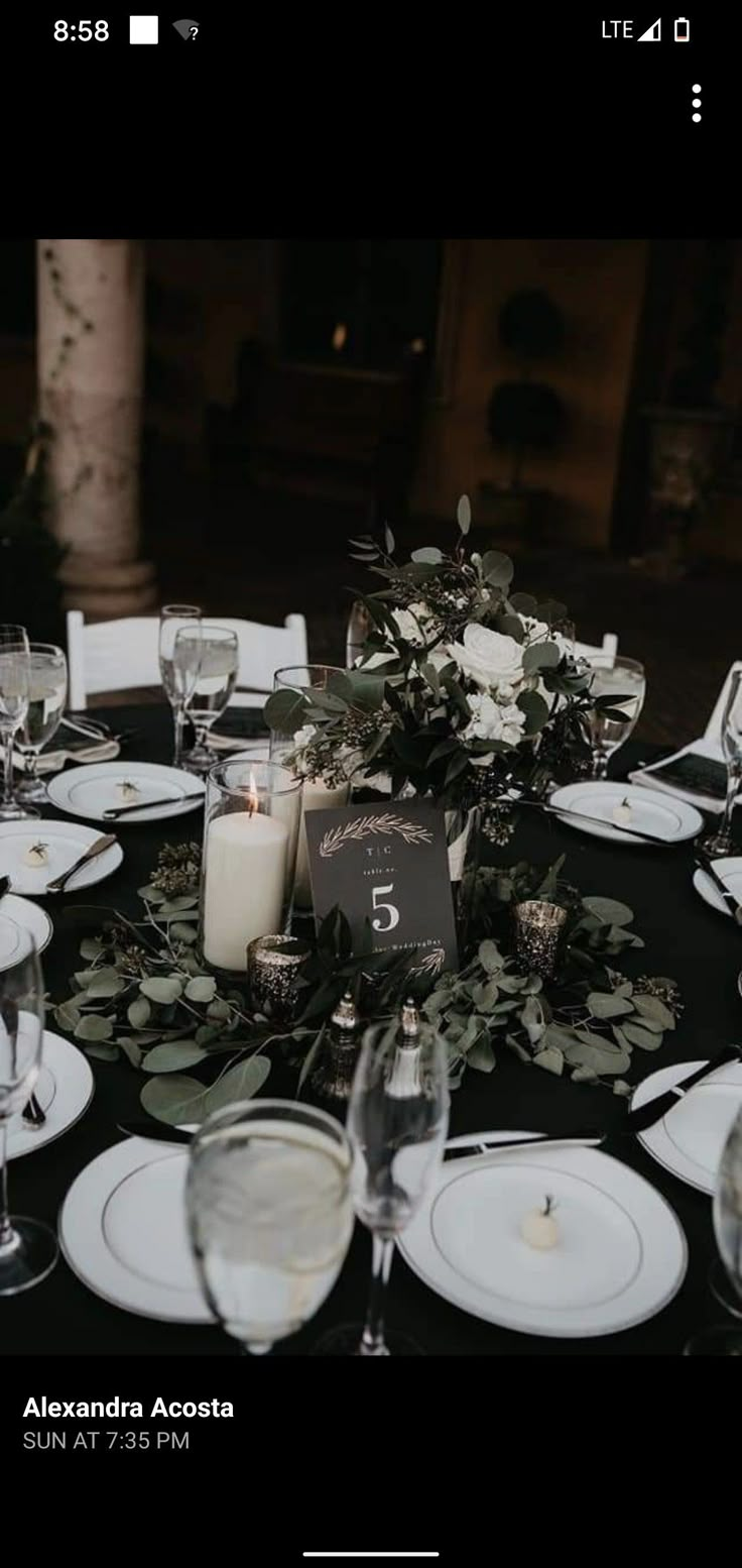 the table is set with candles, plates and napkins for an elegant wedding reception