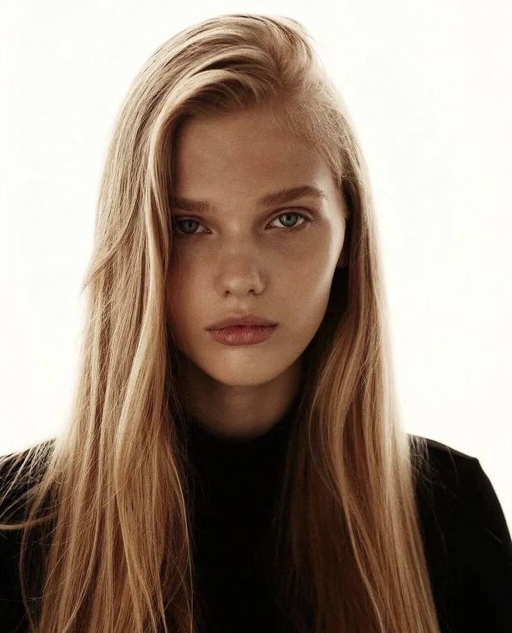 a woman with long blonde hair is posing for the camera and looking at the camera