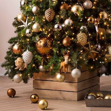 a small christmas tree with gold and silver ornaments on the top is in a wooden box