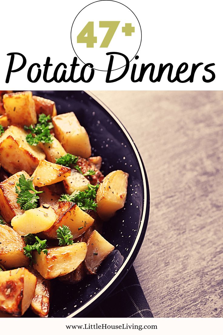 a black plate topped with potatoes and parsley on top of a wooden table next to a