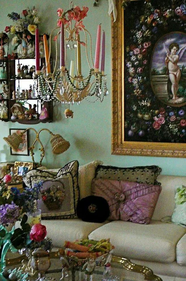 a living room filled with furniture and a chandelier hanging on the wall above it