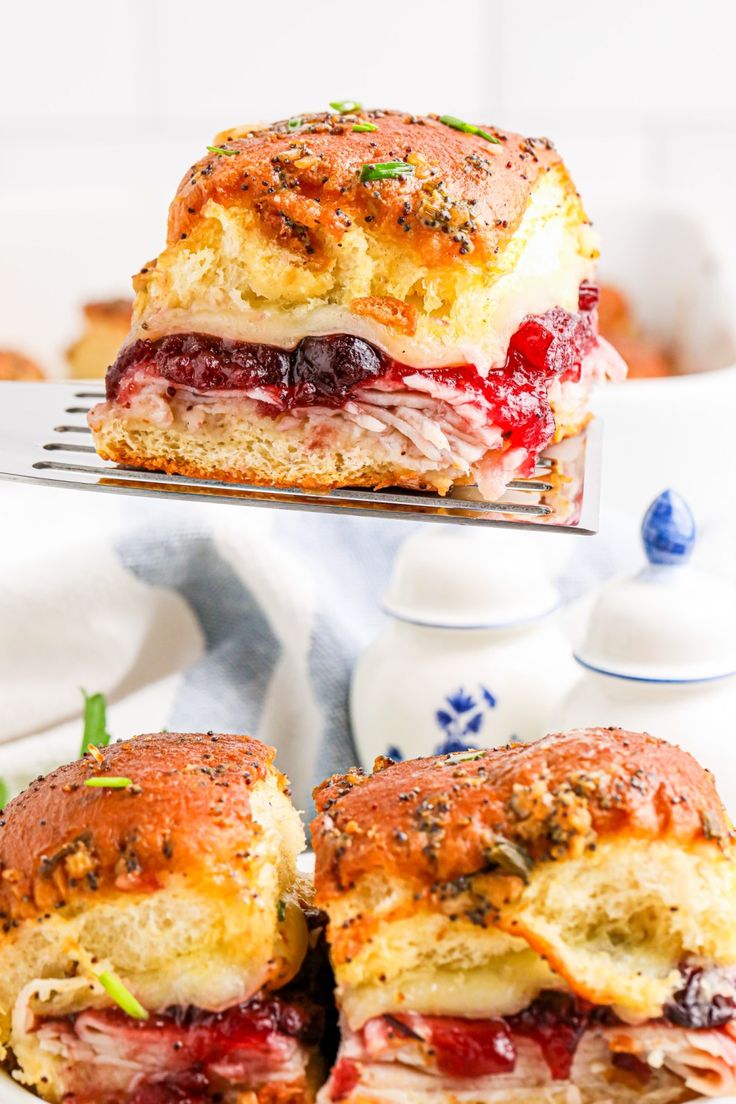 two sandwiches cut in half and stacked on top of each other with cranberry sauce