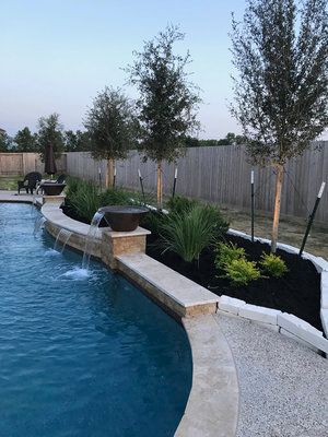 a backyard with a swimming pool and landscaping