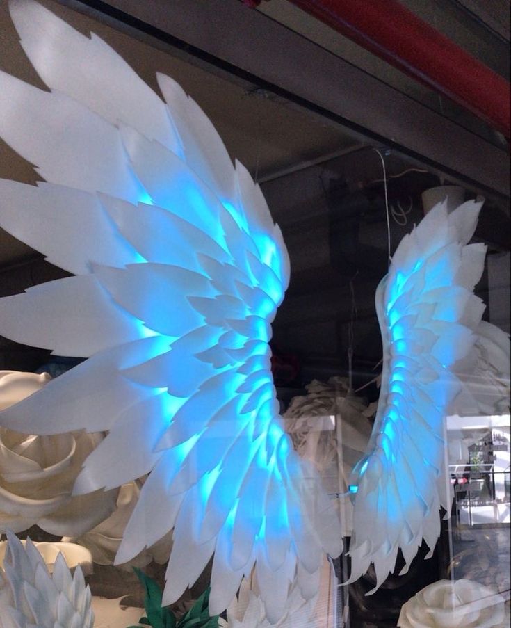 an angel wing is lit up with blue lights