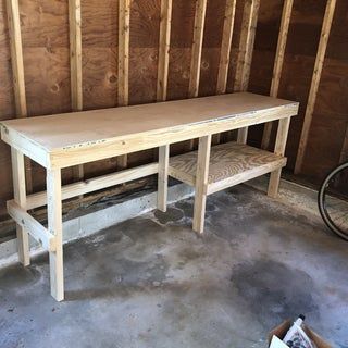 a wooden table and bench in a room under construction