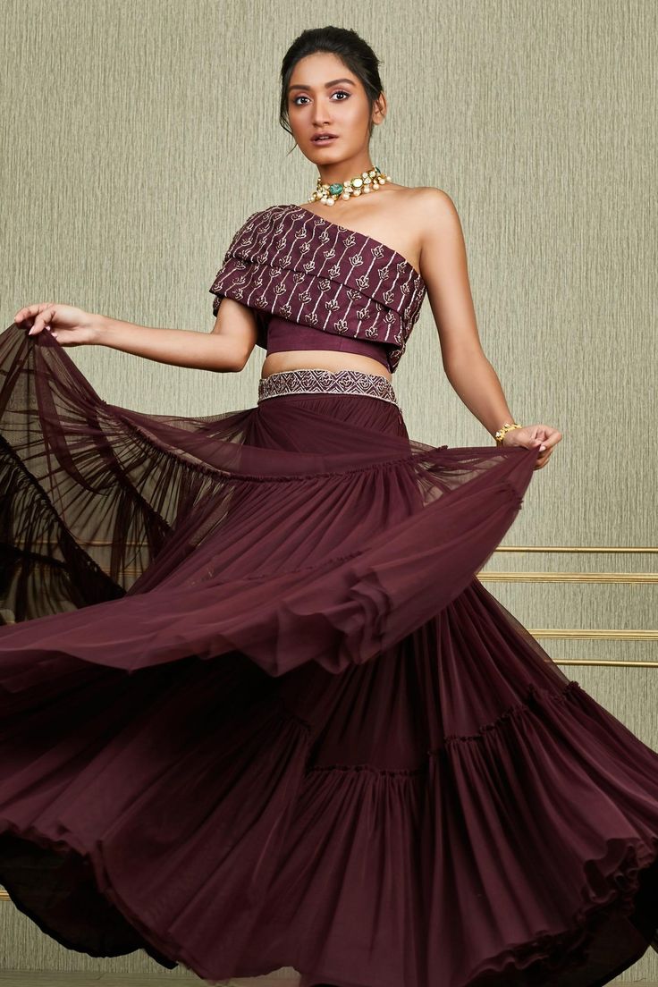 Plum flared lehenga with tiered detail and embroidered waistband. Paired with overlay embroidered one shoulder blouse.
Component: 2
Embroidered
Neckline: Asymmetric
Sleeve Length: Asymmetric
Fabric: Tussar, Net
Color: Maroon
Embroidered sequin, cutdana
Closure:
Lehenga and blouse: Side zip - Aza Fashions Lines Embroidery, Organza Sharara, Purple Lehenga, Gaun Fashion, Choli Designs, Embroidered Belt, Indian Gowns Dresses, Black Saree, Indian Gowns