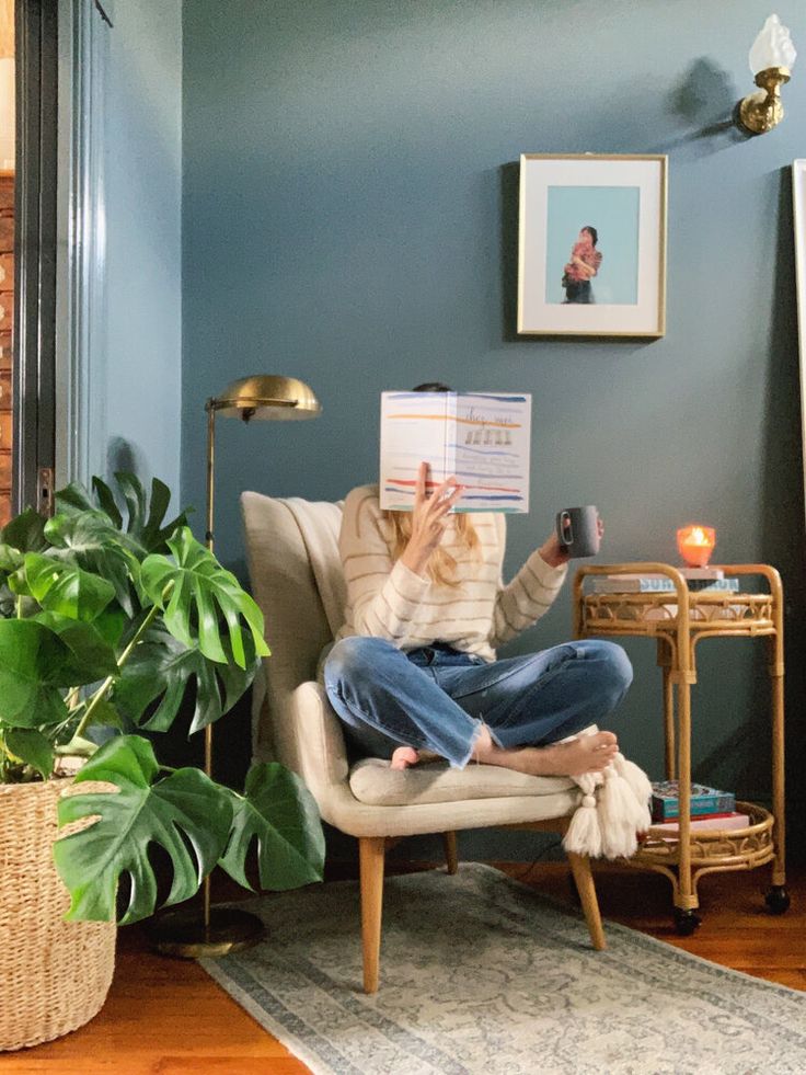 a woman sitting in a chair reading a book