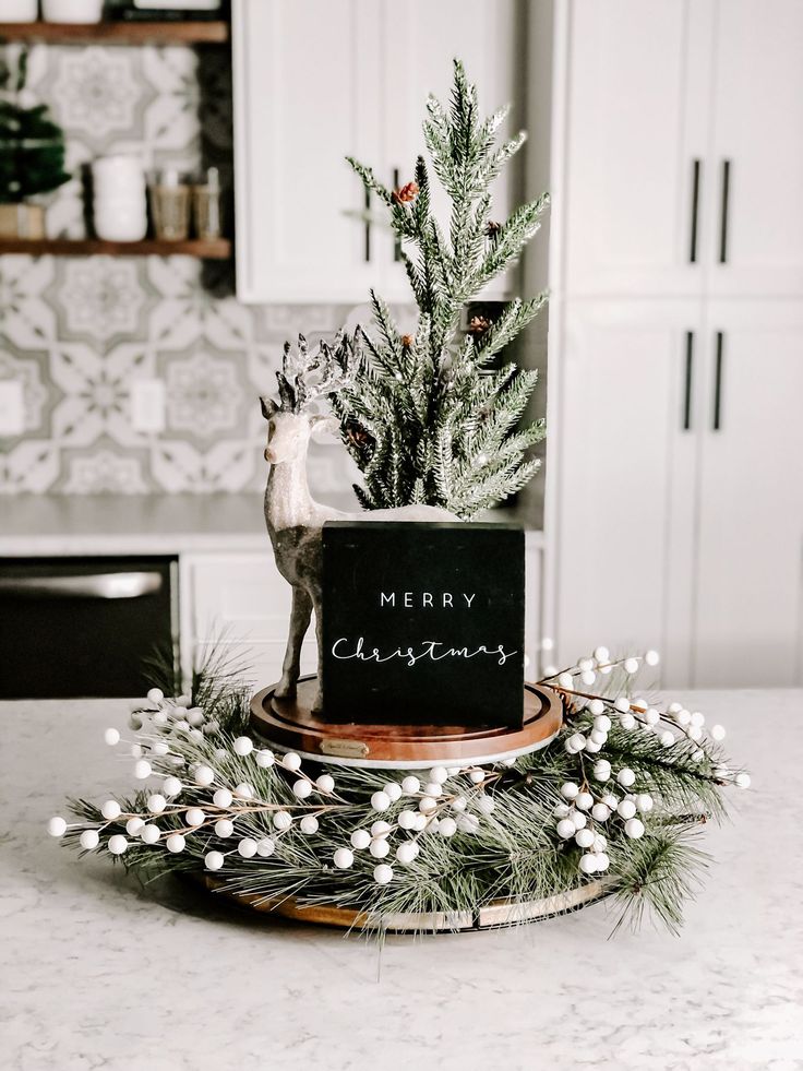 a small christmas tree on top of a wooden plate with a reindeer figure next to it