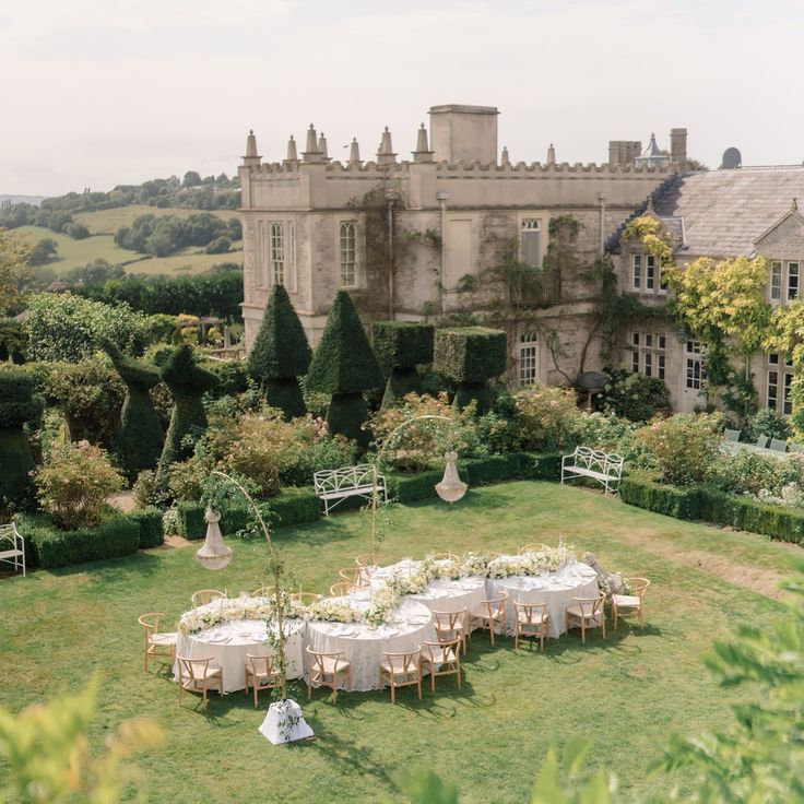 an aerial view of a table set up in the middle of a lawn with chairs and tables