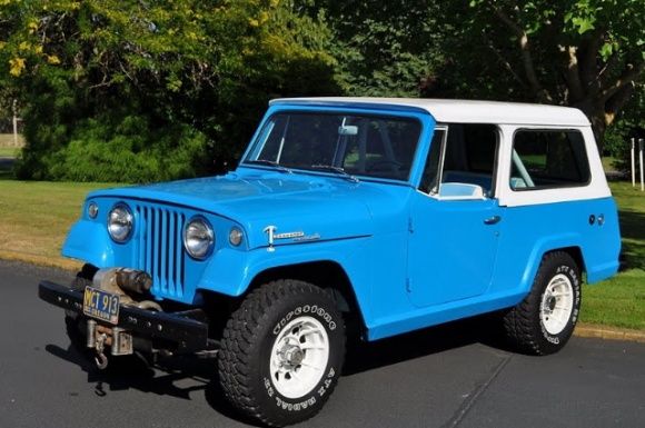 a blue and white jeep is parked on the street