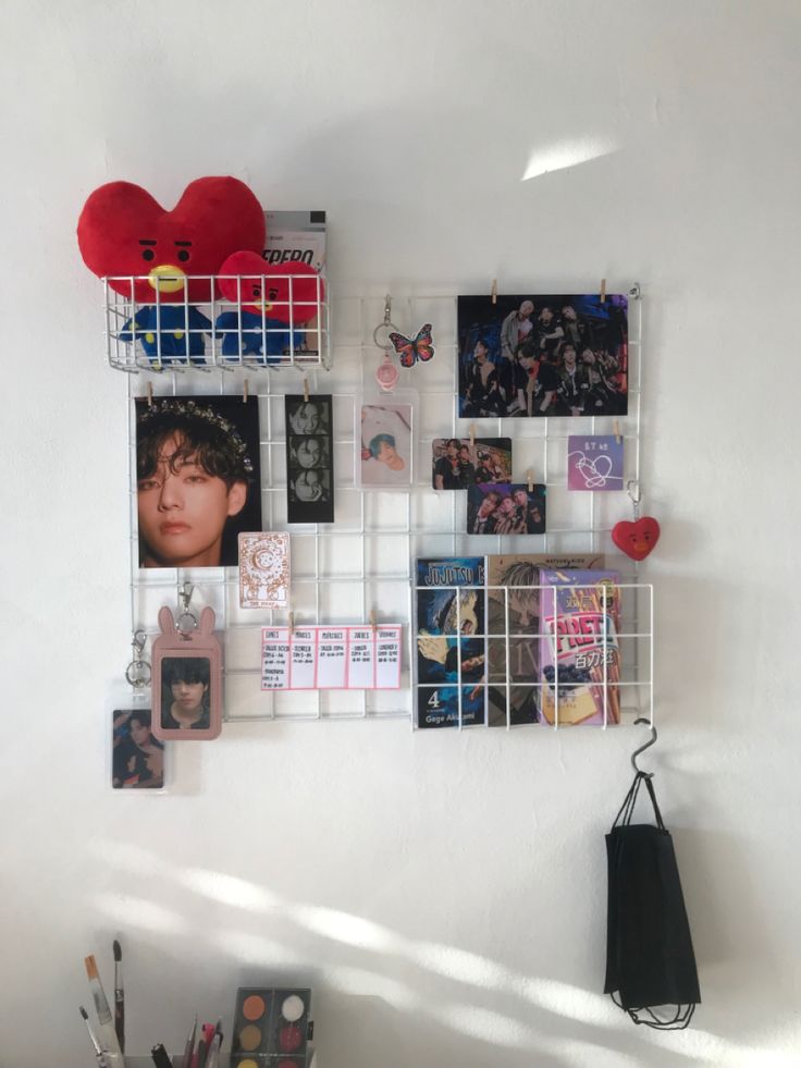 a white wall with several pictures and magnets on it, including a red heart