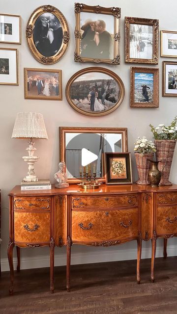 there are many framed pictures on the wall above this antique dresser and sideboard with drawers