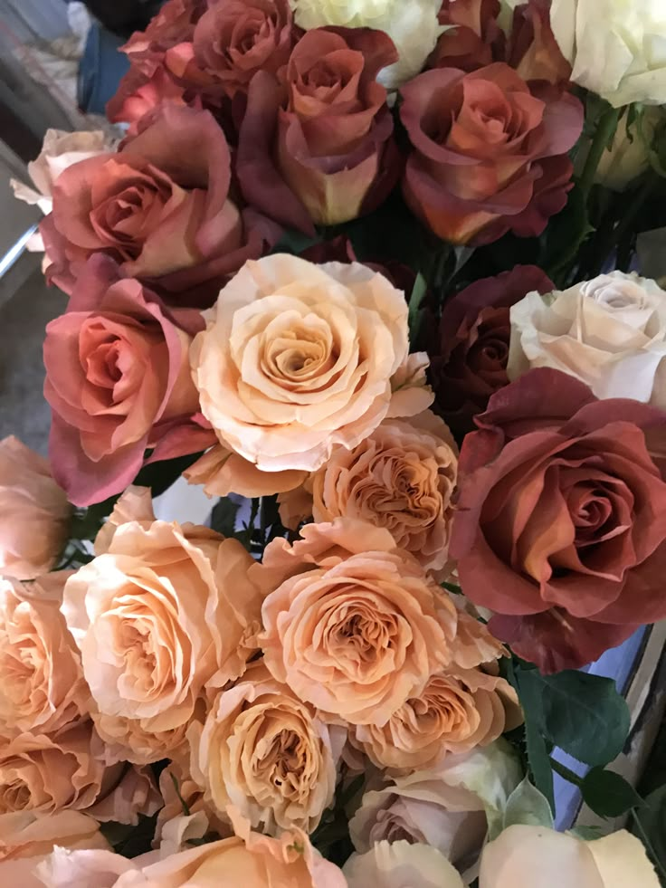 a bunch of flowers that are sitting in a vase on a table with other flowers