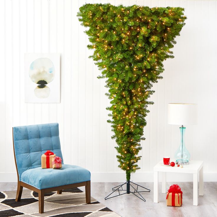 a living room with a chair and a christmas tree in the corner next to a table