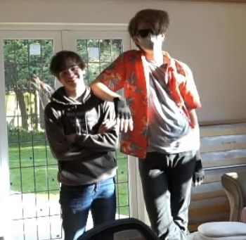 two young men standing next to each other in front of a sliding glass door,