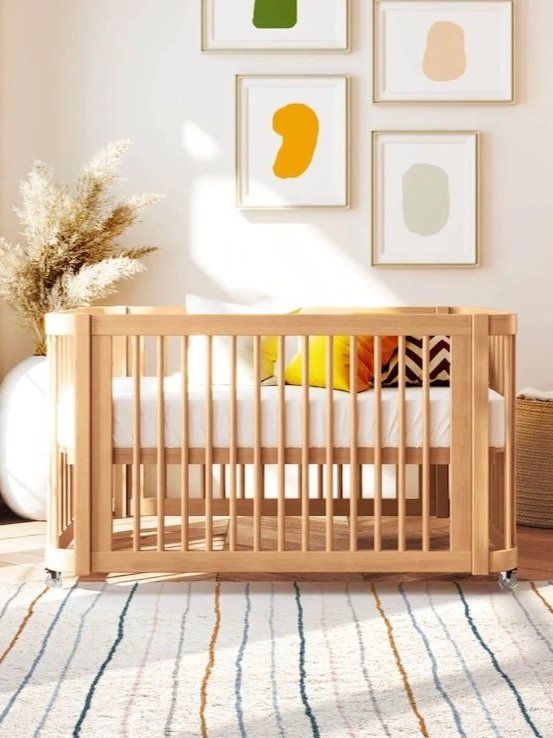 a baby crib in a room with pictures on the wall