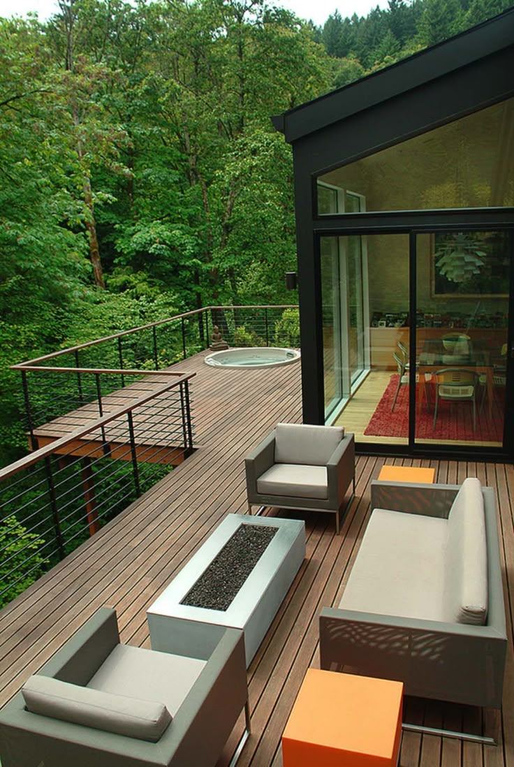 an outdoor deck with furniture and trees in the background