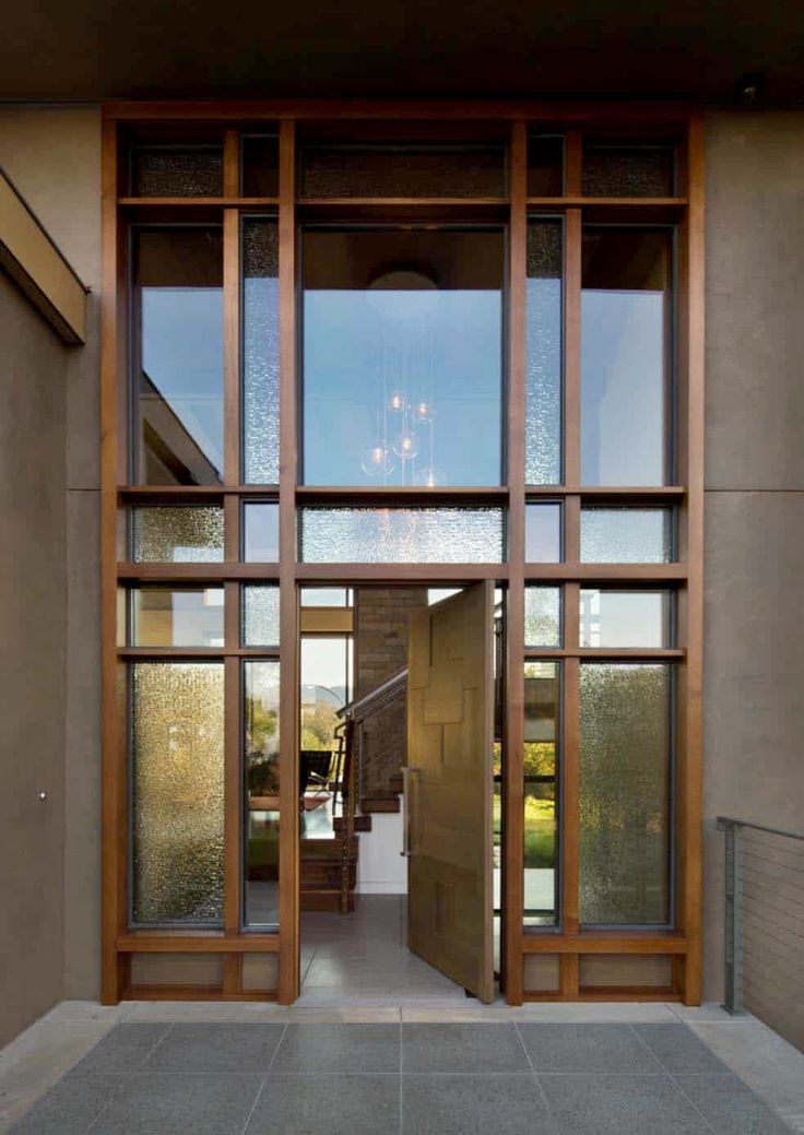 an entrance to a building with glass doors and wood trimmings on the outside