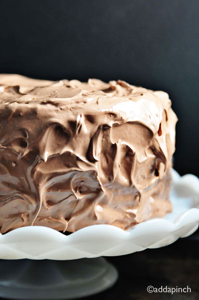 a chocolate frosted cake sitting on top of a white plate