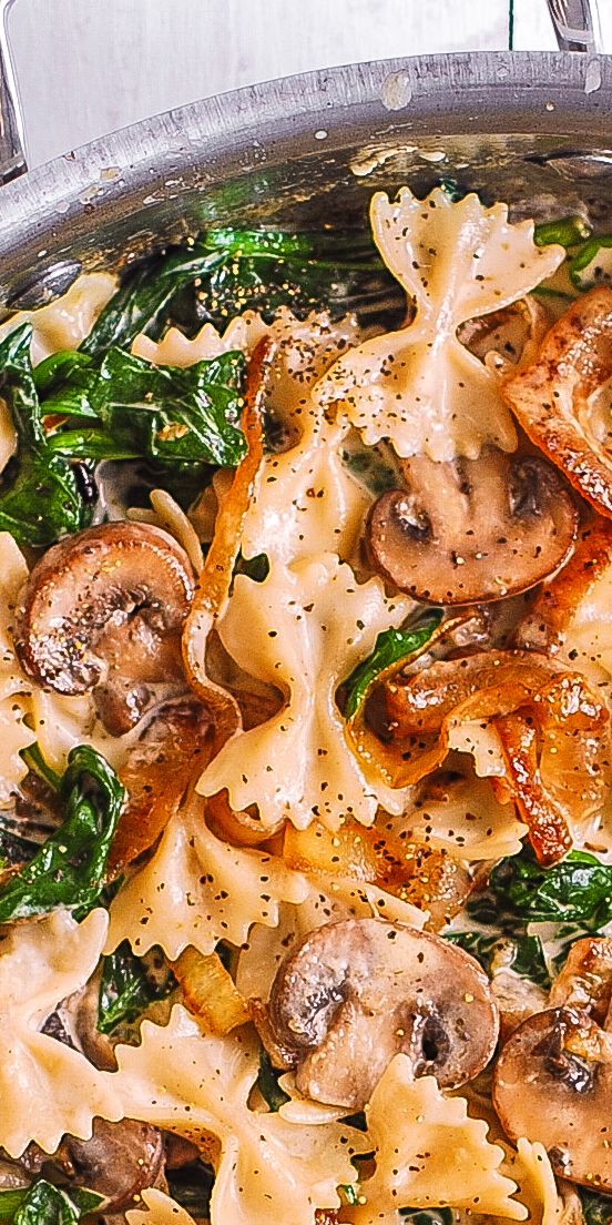 pasta with mushrooms and spinach in a pan