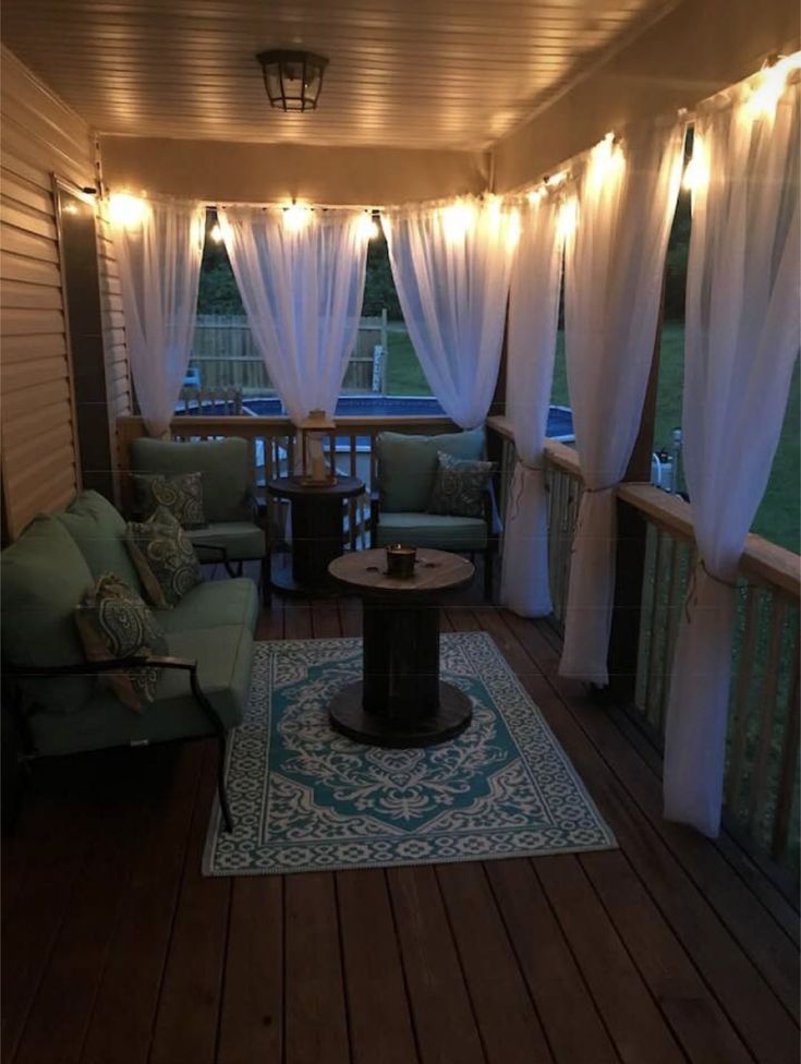 a living room with white curtains and lights on the ceiling