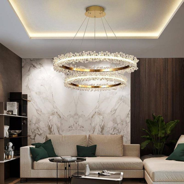 a living room with white couches and a chandelier hanging from the ceiling