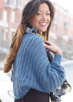 a woman is smiling while holding onto her coat