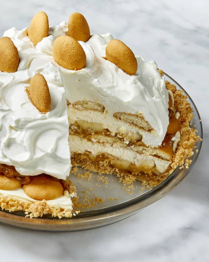 a piece of cake with white frosting and nuts on top is sitting on a plate