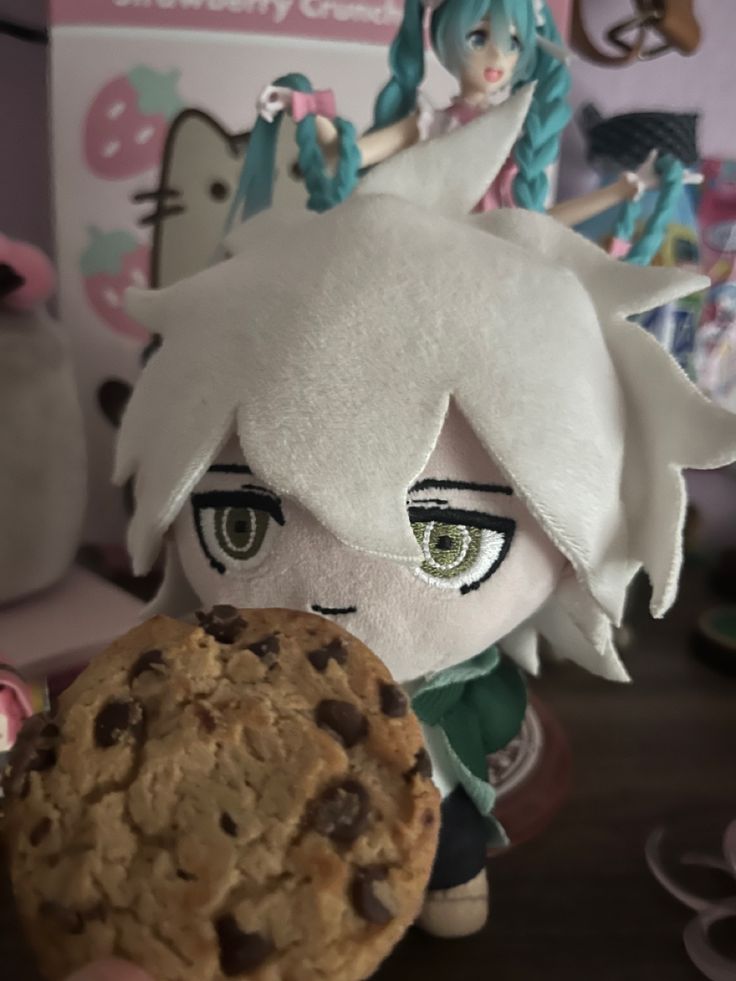 a close up of a stuffed animal holding a cookie