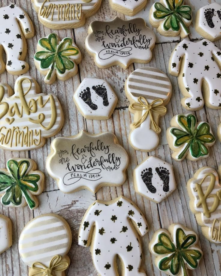 some decorated cookies are laying on a wooden table with green and white decorations around them